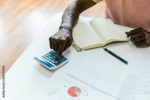 African man crunching numbers in a modern office setting