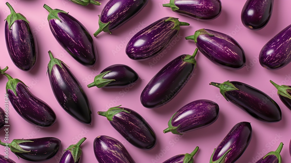 Top view of purple eggplants on a pink background. The eggplants are arranged in a random pattern. The image is well-lit and the colors are vibrant. Top view of purple eggplants on a pink background. The eggplants are arranged in a random pattern. The image is well-lit and the colors are vibrant.