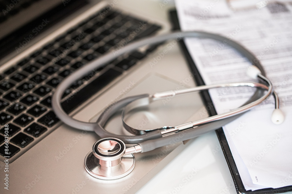 Stethoscope resting on a laptop keyboard, symbolizing the advancement of telemedicine. Stethoscope resting on a laptop keyboard, symbolizing the advancement of telemedicine.