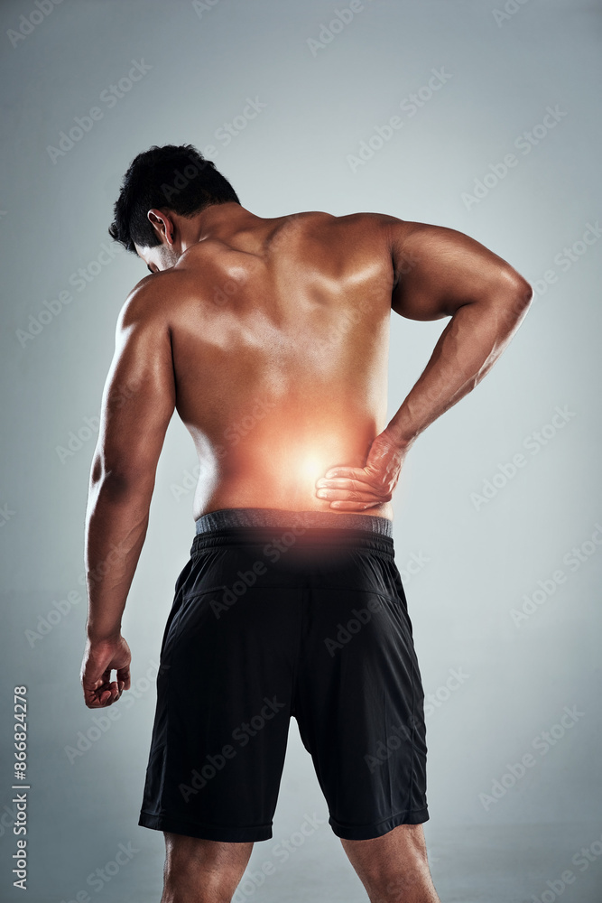 Studio, fitness and man with lower back pain, physio and cramp at gym workout for bodybuilder training. Exercise, overlay and male athlete with muscle injury, red glow and ache on grey background
