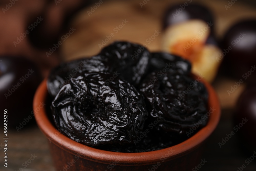 Tasty dried plums (prunes) in bowl on table, closeup Tasty dried plums (prunes) in bowl on table, closeup