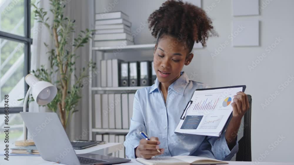 Businesswoman presenting data on tablet during video call in office. Reviewing charts, writing notes, and explaining business analysis in a modern setting Businesswoman presenting data on tablet during video call in office. Reviewing charts, writing notes, and explaining business analysis in a modern setting