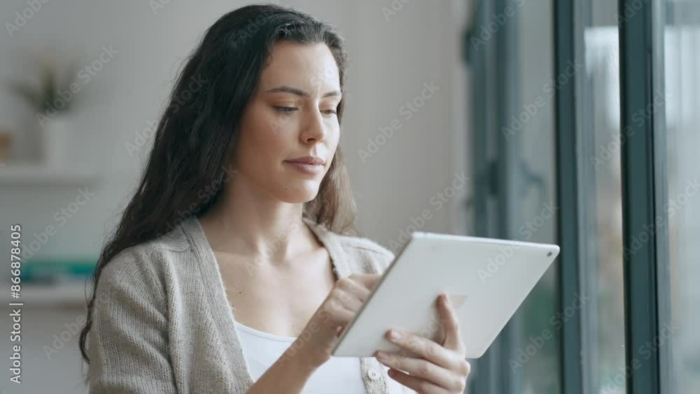 Video of beauty business woman using her digital tablet while sitting on a desk in a modern startup office. Video of beauty business woman using her digital tablet while sitting on a desk in a modern startup office.