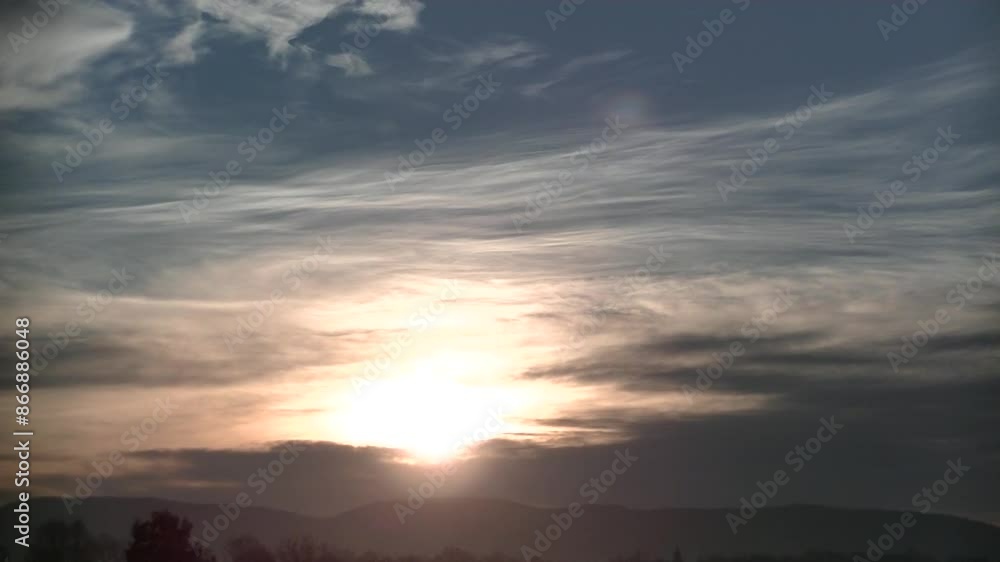 Blue sky with moving clouds, pink, orange and yellow colors, plane in flight and sunlight during sunrise over dark horizon with trees and Silesian Beskid mountains in Poland in December - timelapse. Blue sky with moving clouds, pink, orange and yellow colors, plane in flight and sunlight during sunrise over dark horizon with trees and Silesian Beskid mountains in Poland in December - timelapse.
