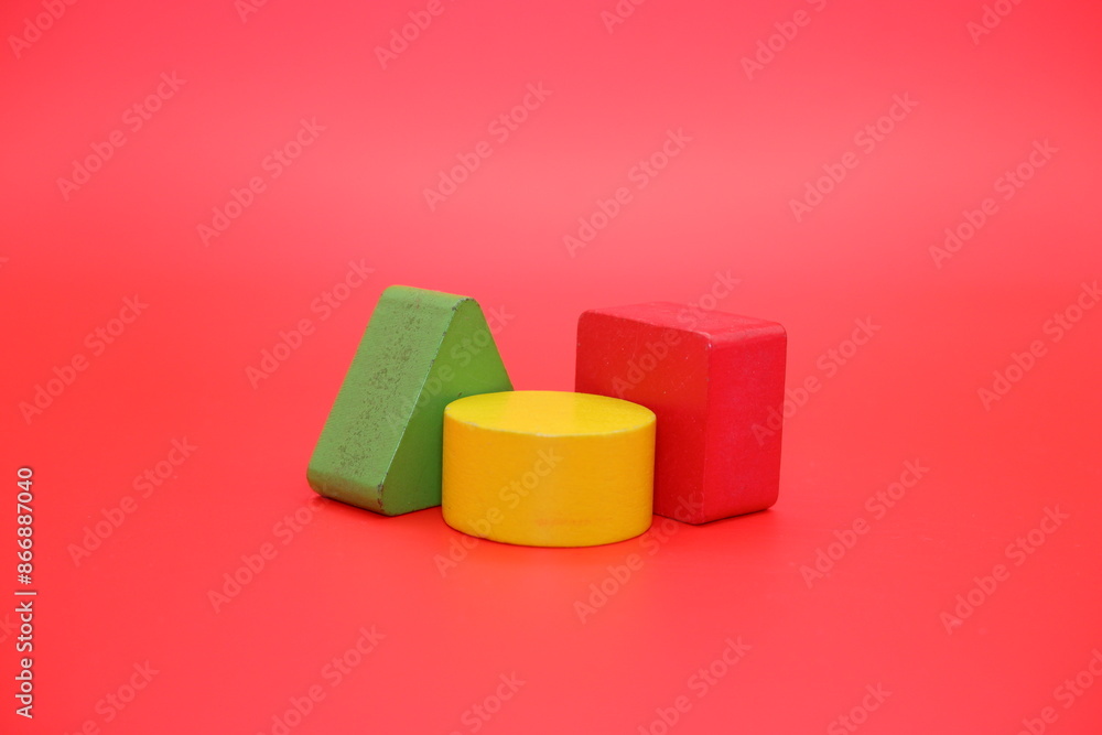 colorful wooden toys isolated red background. wooden toys shaped like triangles, squares and circles. colorful wooden toys isolated red background. wooden toys shaped like triangles, squares and circles.