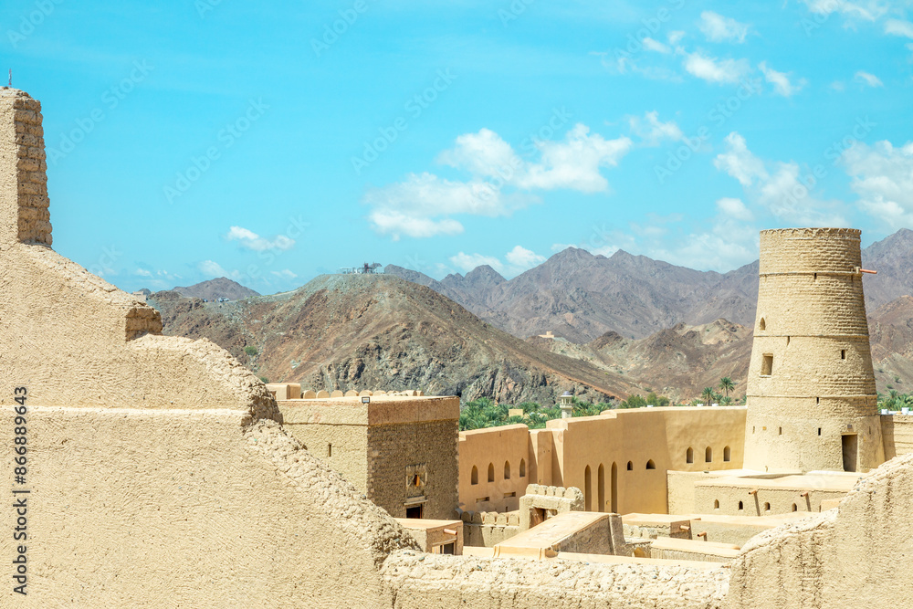 Bahla citadel fortress stone walls and round towers with mountains in the background, Bahla, Oman Bahla citadel fortress stone walls and round towers with mountains in the background, Bahla, Oman