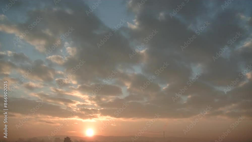 Misty and smoggy view with blue sky, pink, orange and yellow colors, moving clouds during sunrise, chimney and fumes over horizon of Silesian Beskid mountains in Poland on winter heating season. Misty and smoggy view with blue sky, pink, orange and yellow colors, moving clouds during sunrise, chimney and fumes over horizon of Silesian Beskid mountains in Poland on winter heating season.