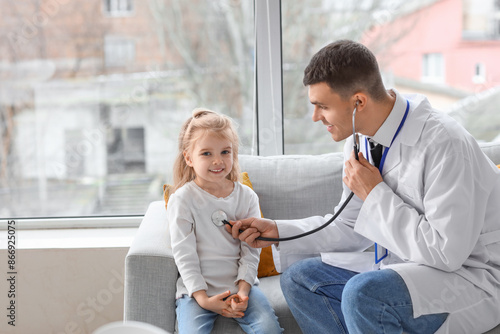 Male pediatrician examining...