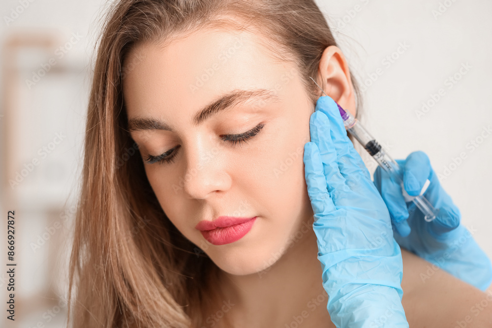 Young woman receiving filler injection in beauty salon Young woman receiving filler injection in beauty salon