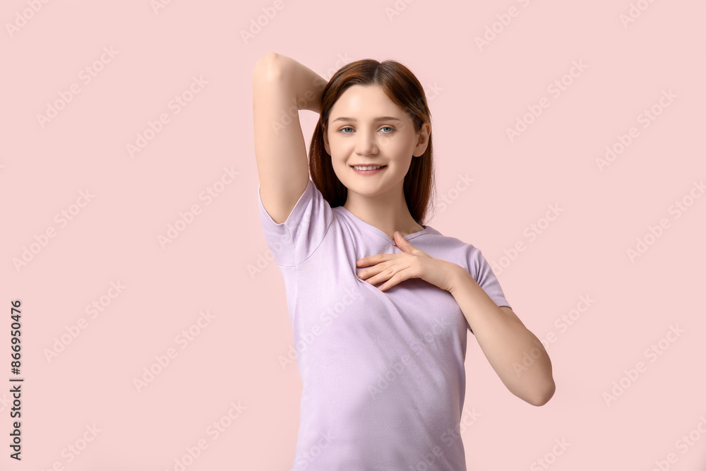 Young woman checking her breast on light pink background Young woman checking her breast on light pink background