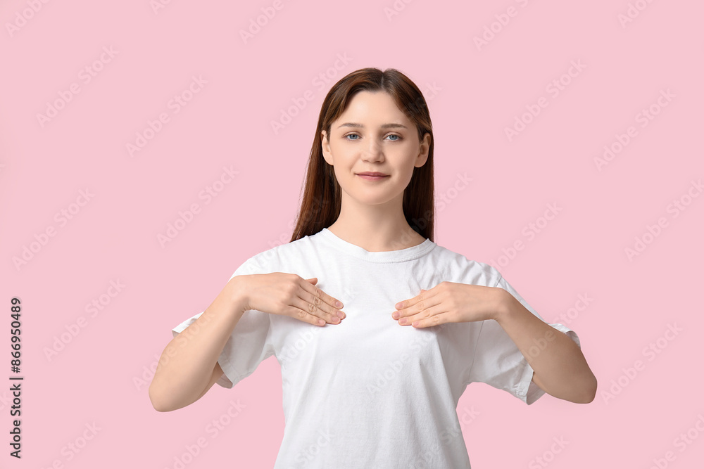 Young woman checking her breast on light pink background Young woman checking her breast on light pink background
