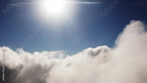 The flight is like a dream. Aerial view low flight over fluffy clouds towards the sun. Aeronautics in the heaven. Exclusive footage from the first person. Like in a dream