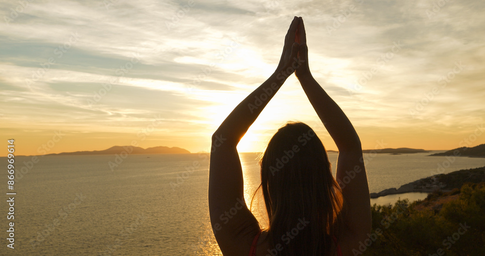 Φωτογραφία CLOSE UP, LENS FLARE: Morning meditation of a young lady at sunrise by the sea