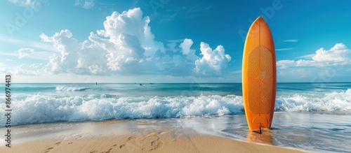 Orange Surfboard on Sandy Beach with Blue Sky