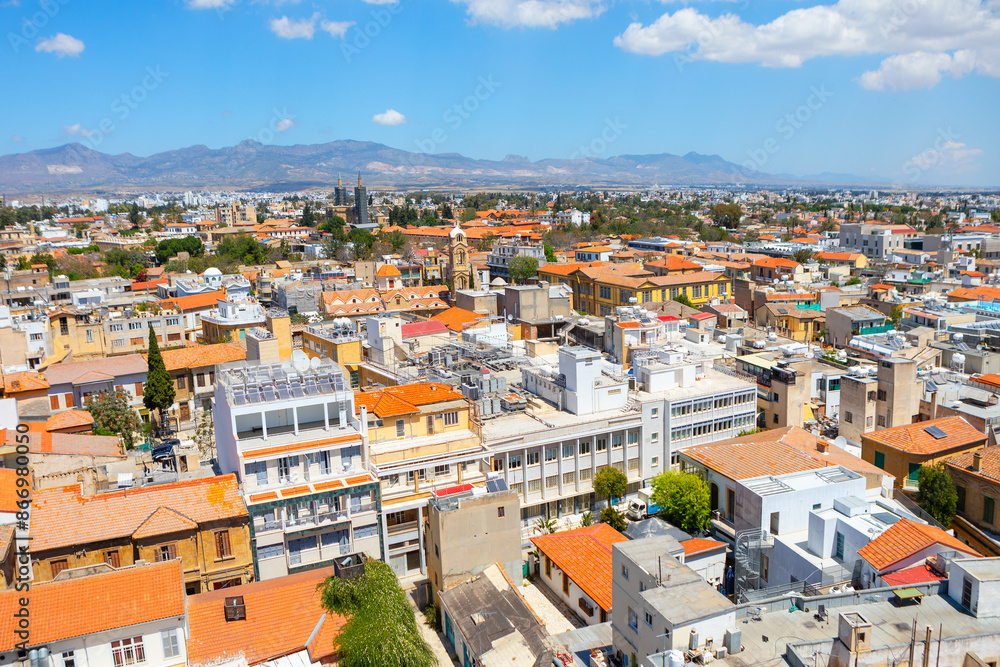 Obraz premium Nicosia City view with many buildings and a mountain in the background. Nicosia urban landscape featuring a multitude of buildings in Cyprus