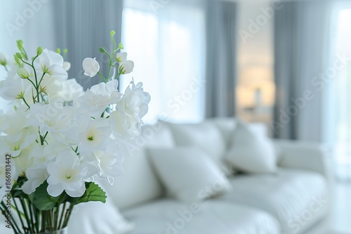 Interior of modern room with comfortable sofa. Blurred Modern white living room interior with sofa, furniture and flowers © Boraryn