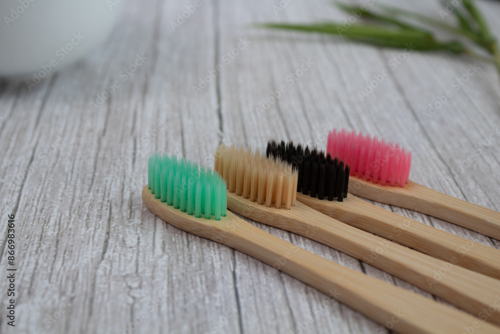 Closeup of pair of toothbrushes made with bamboo wood of various colors on table Closeup of pair of toothbrushes made with bamboo wood of various colors on table