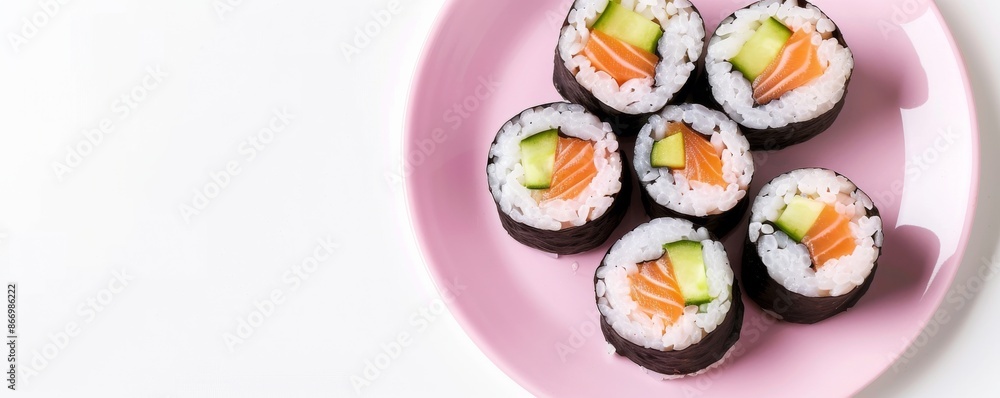 Sushi rolls with salmon and cucumber on a pink plate, top view. Japanese cuisine and food presentation concept Sushi rolls with salmon and cucumber on a pink plate, top view. Japanese cuisine and food presentation concept