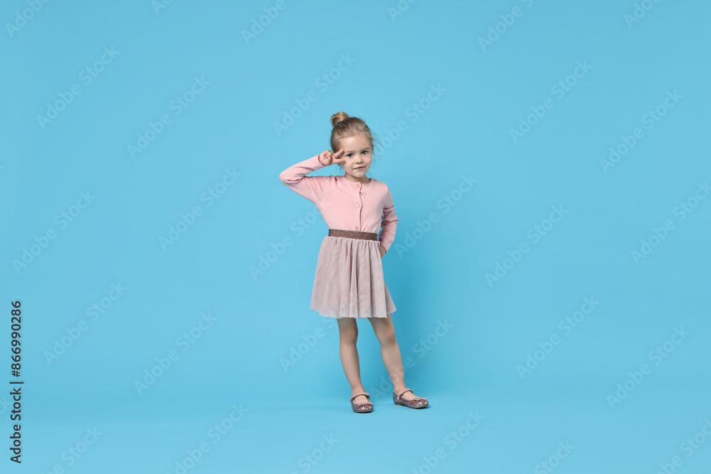 Cute little girl dancing on light blue background Cute little girl dancing on light blue background