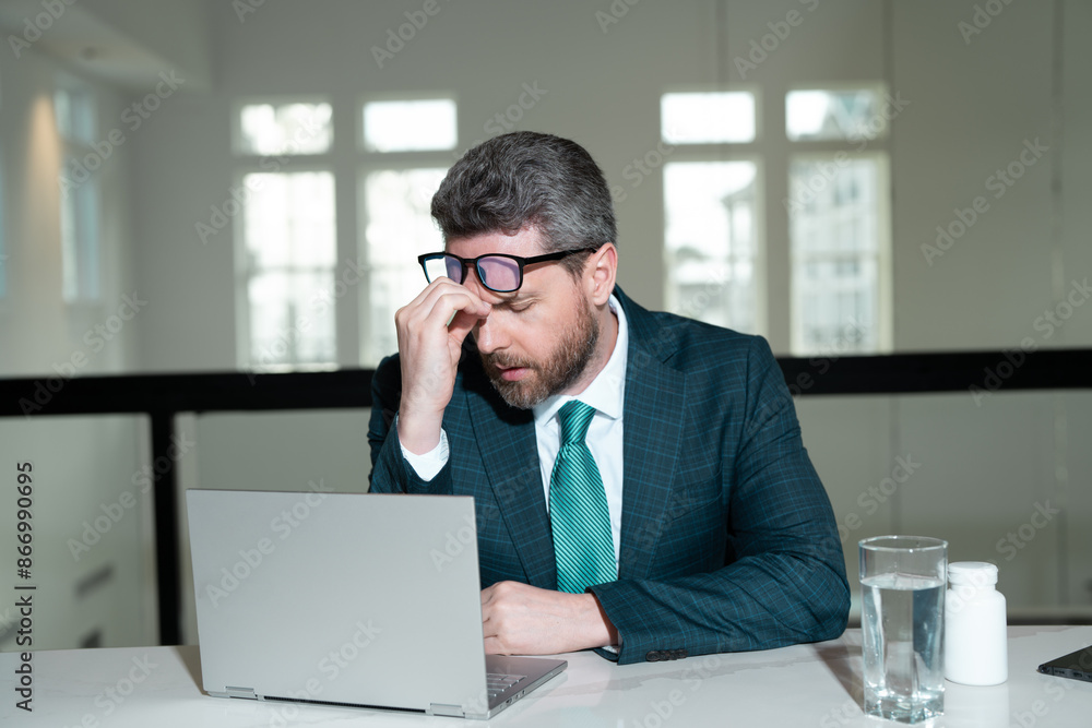 Tired man having a terrible headache. Exhausted man feeling unhealthy, upset about headache illness. Stressed middle-aged man having headache. Migraine and headache concept. Tired man having a terrible headache. Exhausted man feeling unhealthy, upset about headache illness. Stressed middle-aged man having headache. Migraine and headache concept.