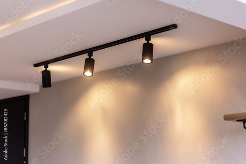 Lighting equipment on the wall in the living room. Spotlights under the ceiling. Track LED-lighting system