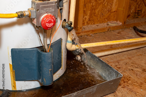 Water gushing out of water heater drain, into drain pan.
