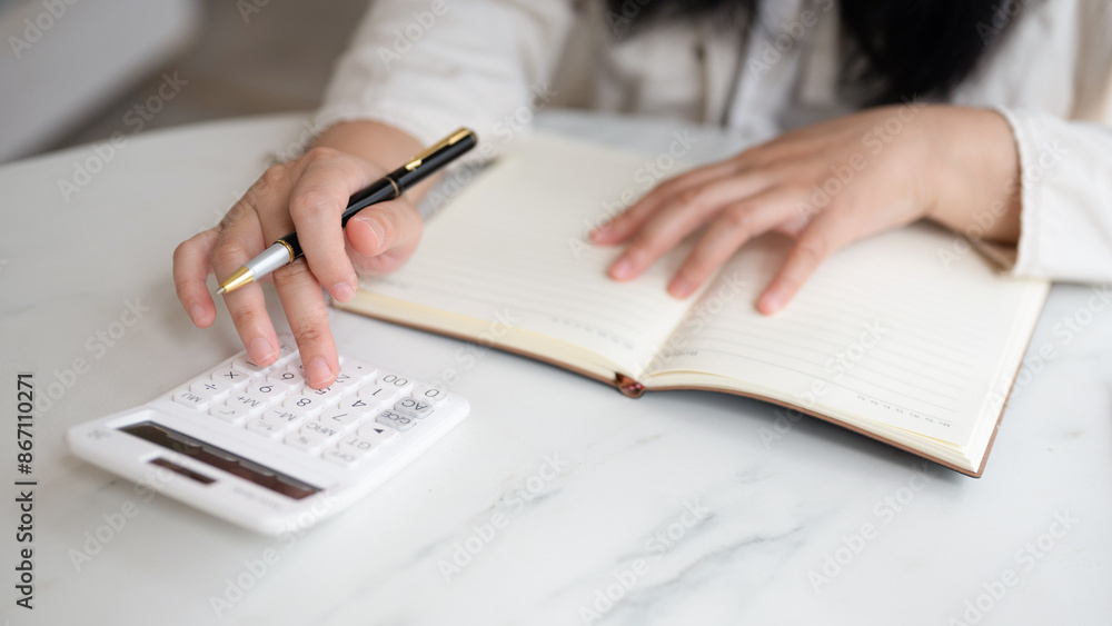 Close-up of businesswoman hands using a calculator to check company finances and earnings and budget. Close-up of businesswoman hands using a calculator to check company finances and earnings and budget.