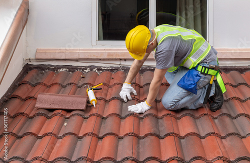 Foto Construction worker is inspecting roof tile cracked.
