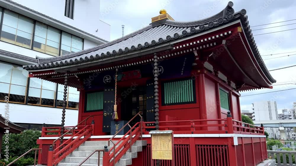 Traditional Japanese temple with red exterior and steps in an urban setting Traditional Japanese temple with red exterior and steps in an urban setting