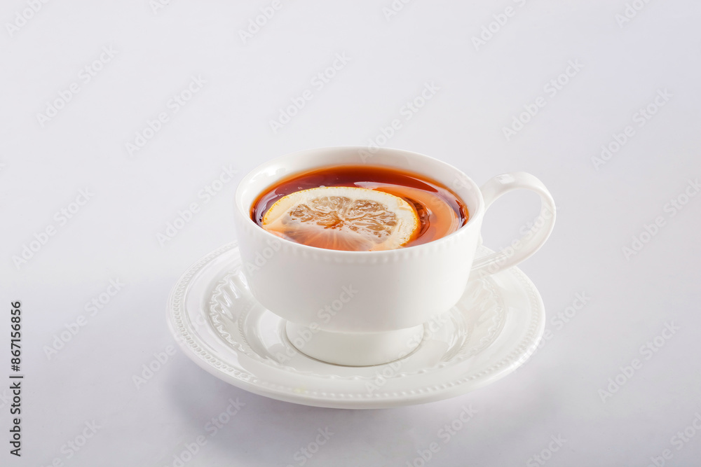 Hot Lemon Tea with lime slice served in cup isolated on grey background side view of chinese hot drink Hot Lemon Tea with lime slice served in cup isolated on grey background side view of chinese hot drink
