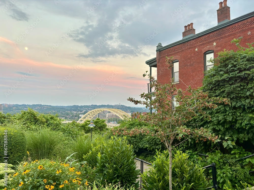 Naklejka premium Sunset over Daniel Carter Beard Bridge, brick building in Cincinnati