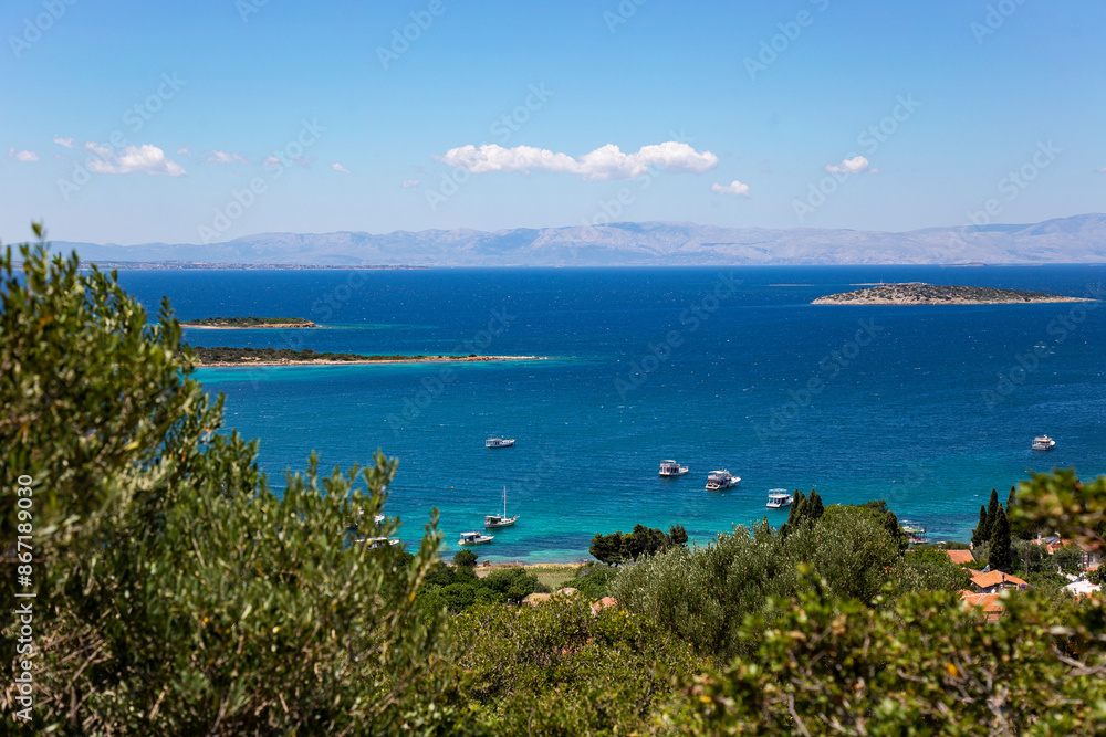 Scenic coastal view with clear cyan sea, fishing boats and islands Scenic coastal view with clear cyan sea, fishing boats and islands