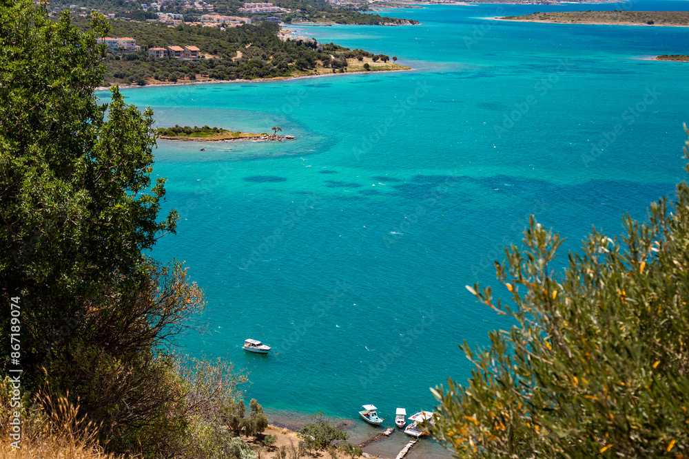 Naklejka premium Scenic coastal view with clear cyan sea, fishing boats and islands
