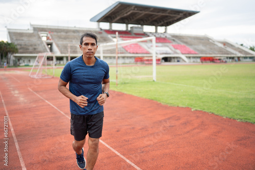 Mature fitness Asia man running on racetrack  © chachamp