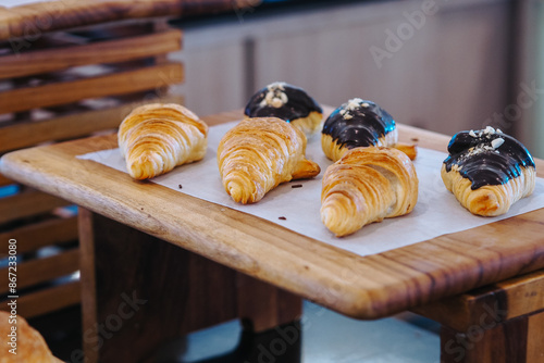 croisants on a wooden table. perfect for recipes, articles, catalogues, commercials, or any cooking contents. photo