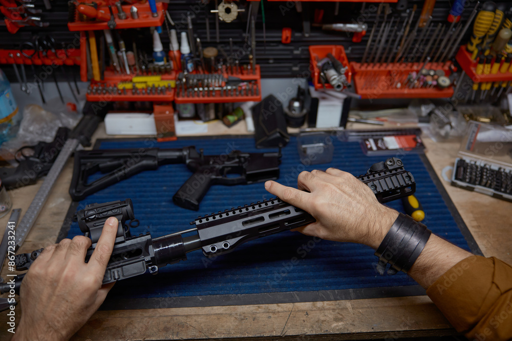 Man disassembles and cleans a rifle in a workshop Man disassembles and cleans a rifle in a workshop