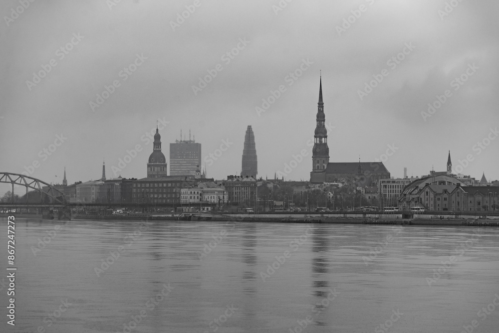 Fototapeta premium cloudy city with brigde over the river daugava