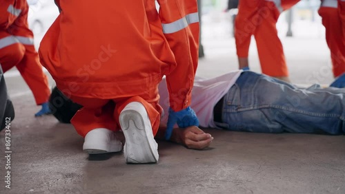Asian injured man was lying on the ground with emergency medical technician (EMT) coming to help
