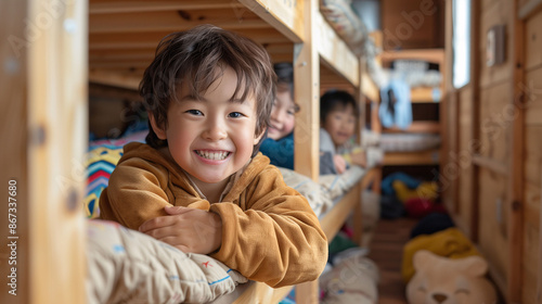 A cheerful boy on his bunk bed in the summer camp cabin with his friends in the background. Concept of vacation, camps, and summer activities.
