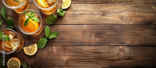 Refreshing summer beverage - tea or juice with ice and mint displayed on a wooden table, with space for text, in a horizontal layout