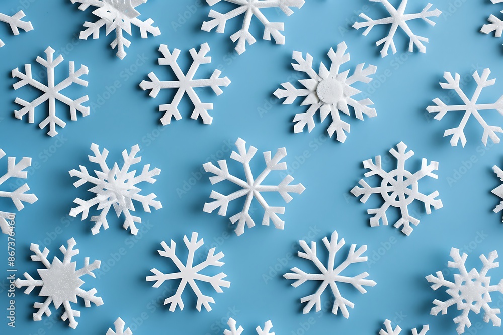 A pattern of minimalist, white snowflakes on a cool blue background A pattern of minimalist, white snowflakes on a cool blue background