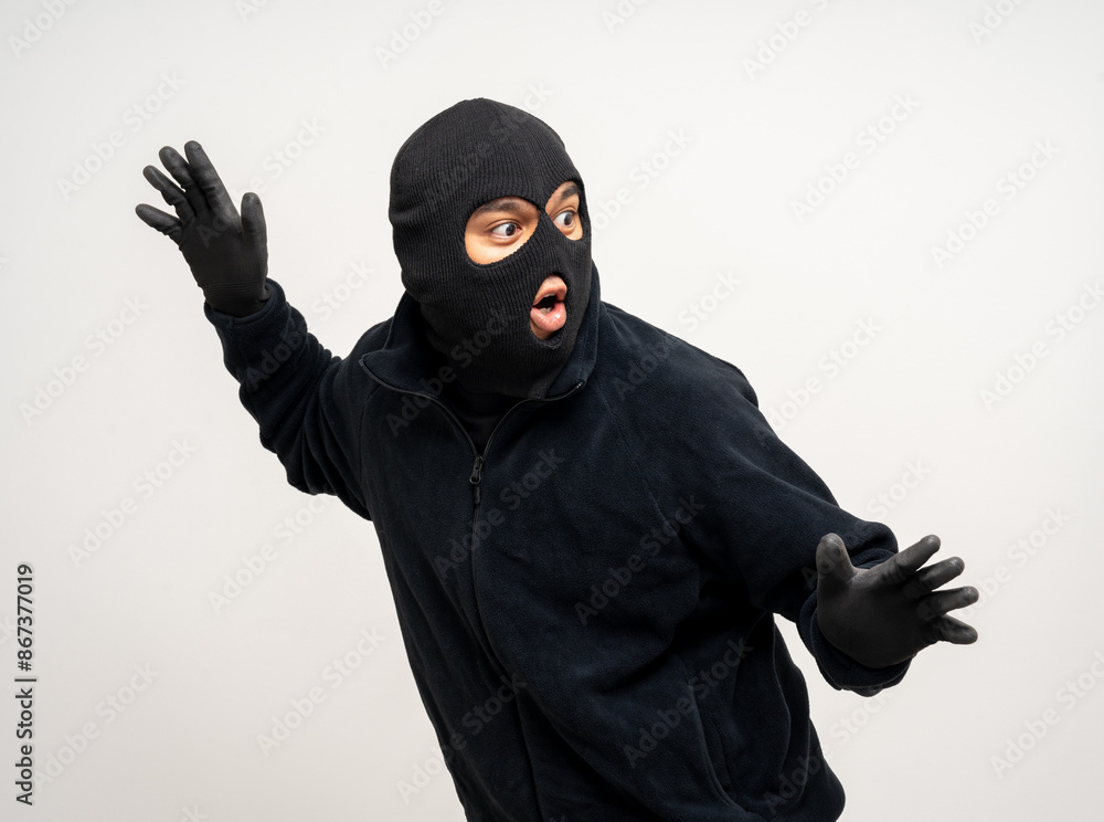Thief in uniform black jacket various pose on isolated background. The Robber terrorism criminal escapes with balaclava and crowbar entering a house for stealing Housebreak Thief in uniform black jacket various pose on isolated background. The Robber terrorism criminal escapes with balaclava and crowbar entering a house for stealing Housebreak