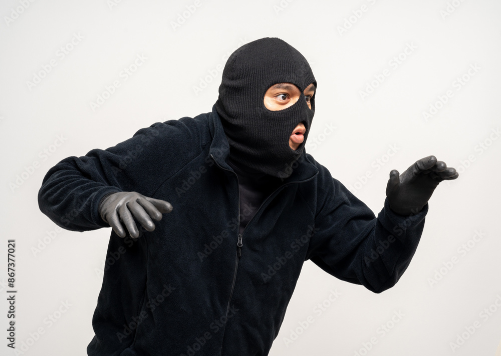 Thief in uniform black jacket various pose on isolated background. The Robber terrorism criminal escapes with balaclava and crowbar entering a house for stealing Housebreak Thief in uniform black jacket various pose on isolated background. The Robber terrorism criminal escapes with balaclava and crowbar entering a house for stealing Housebreak