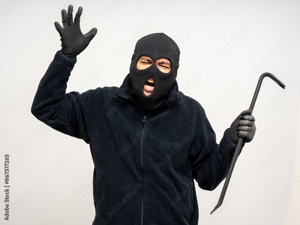 Thief in uniform black jacket various pose on isolated background. The Robber terrorism criminal escapes with balaclava and crowbar entering a house for stealing Housebreak Thief in uniform black jacket various pose on isolated background. The Robber terrorism criminal escapes with balaclava and crowbar entering a house for stealing Housebreak