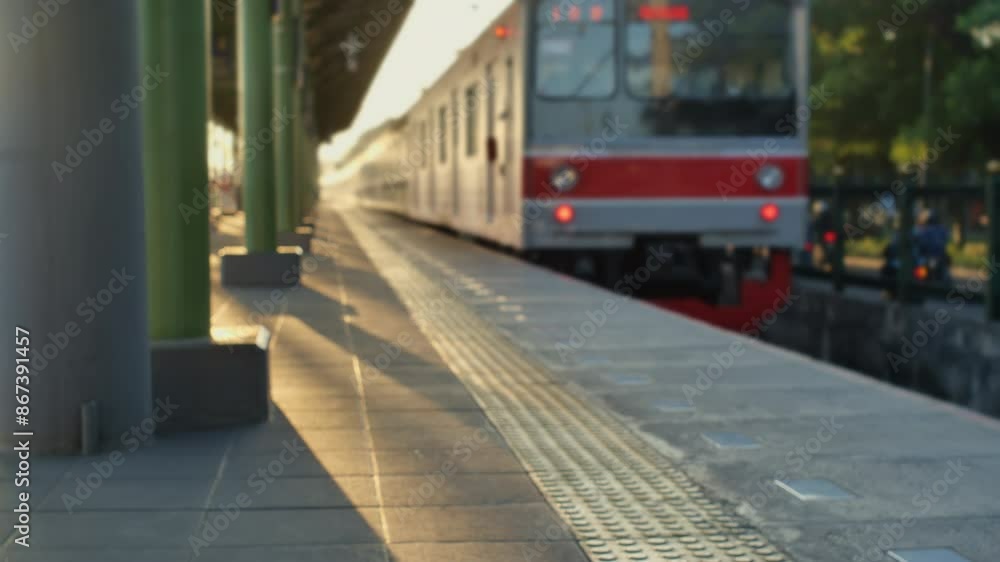 Blur scene of a commuterline electric train in the morning leaving the station, highway traffic next to it, yellowish sunlight. Blur scene of a commuterline electric train in the morning leaving the station, highway traffic next to it, yellowish sunlight.