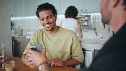 фотографія Cheerful friends resting restaurant exchange phone numbers closeup