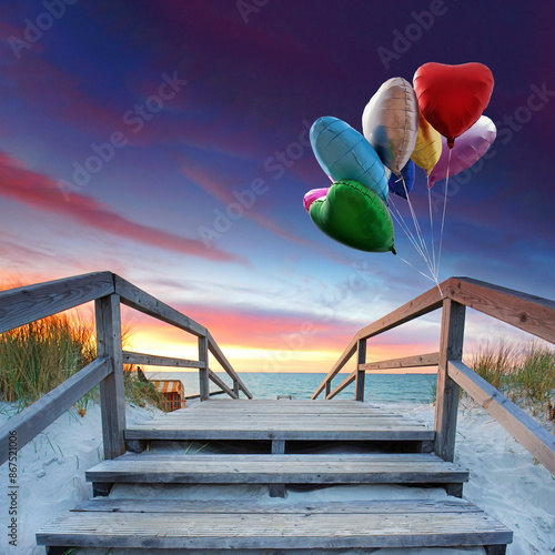 Fototapeta Naklejka Na Ścianę i Meble -  wooden pier with colorful heart shaped balloons in the dunes of Baltic Sea beach