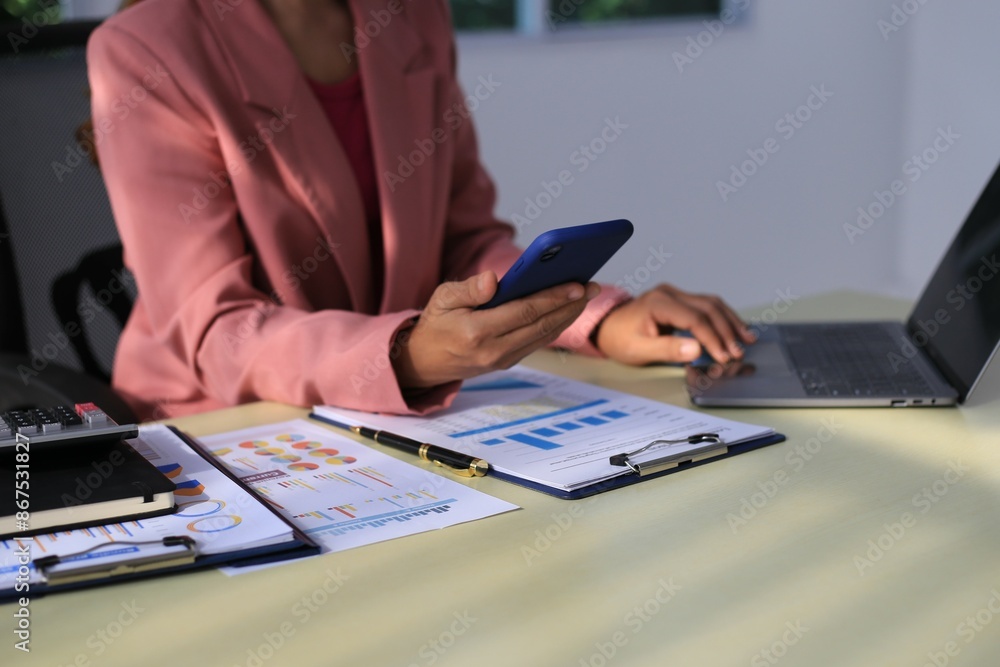Fototapeta premium Image of a young Asian female company employee smiling and holding a digital tablet standing on a white background.