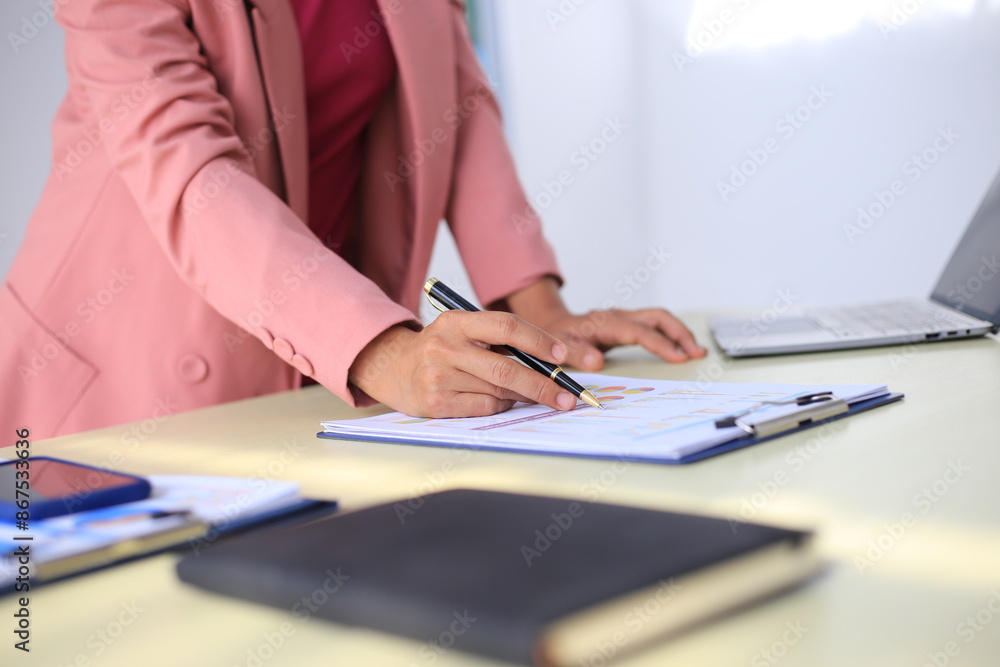 Image of a young Asian female company employee smiling and holding a digital tablet standing on a white background. Image of a young Asian female company employee smiling and holding a digital tablet standing on a white background.