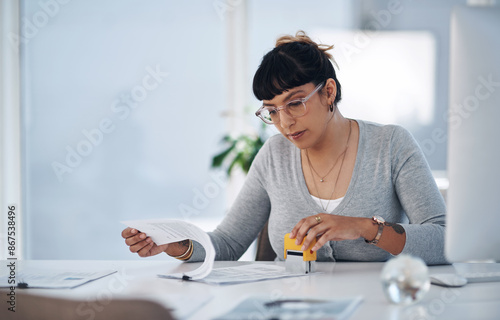 Business woman, reading and paperwork with stamp for approval, review or validation at office. Female person, accountant or auditor checking documents, insurance or contract for policy or agreement photo